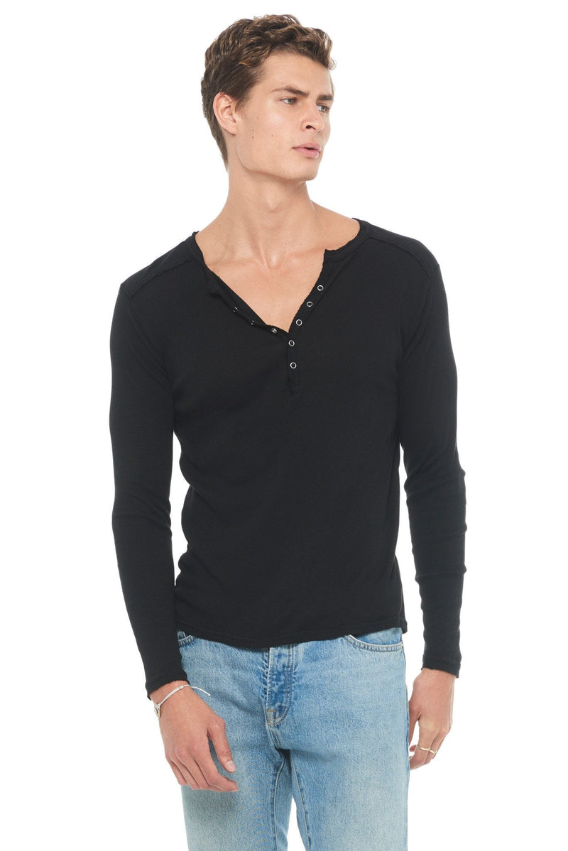 Man wearing a black long sleeve henley shirt with denim